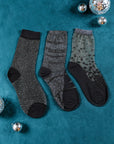 3 paires de chaussettes transparentes à paillettes argentées Atelier St Eustache posées à plat dans une ambiance hivernale pour Noël