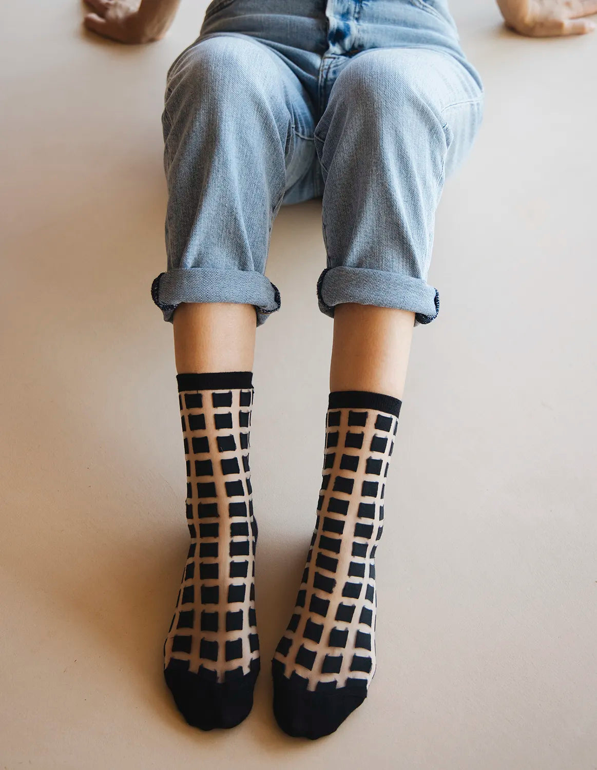 chaussettes transparentes à carreaux noirs jean bleu vue de haut les genoux relevés