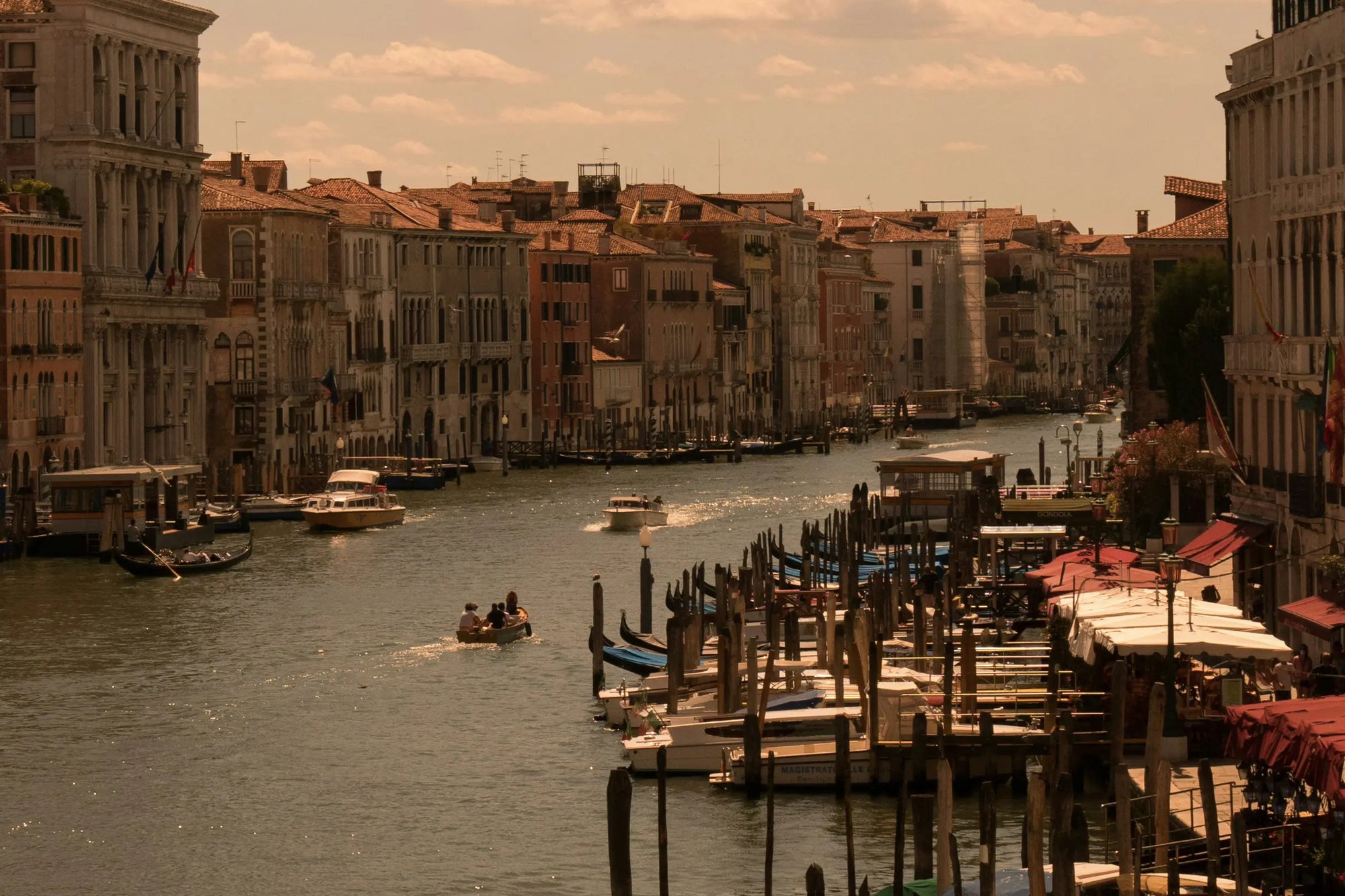 Photographie de la ville de Venise, montrant les palines de gondoles au bord des canaux. 