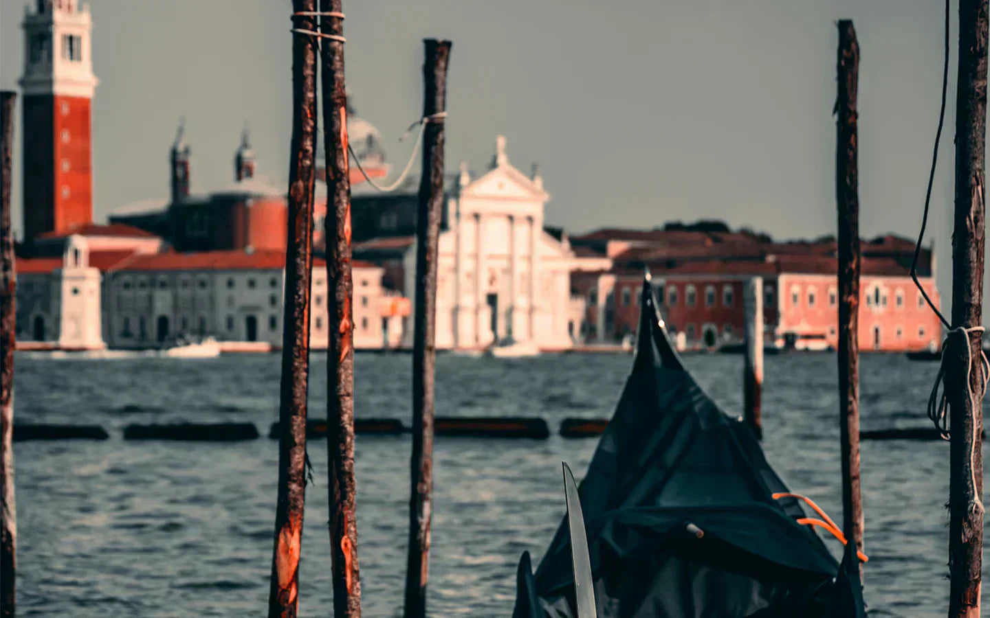 Photographie de la ville de Venise, montrant l'architecture de la ville en arrière plan et une gondole au premier plan. 