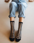 chaussettes transparentes à carreaux noirs jean bleu vue de haut les genoux relevés