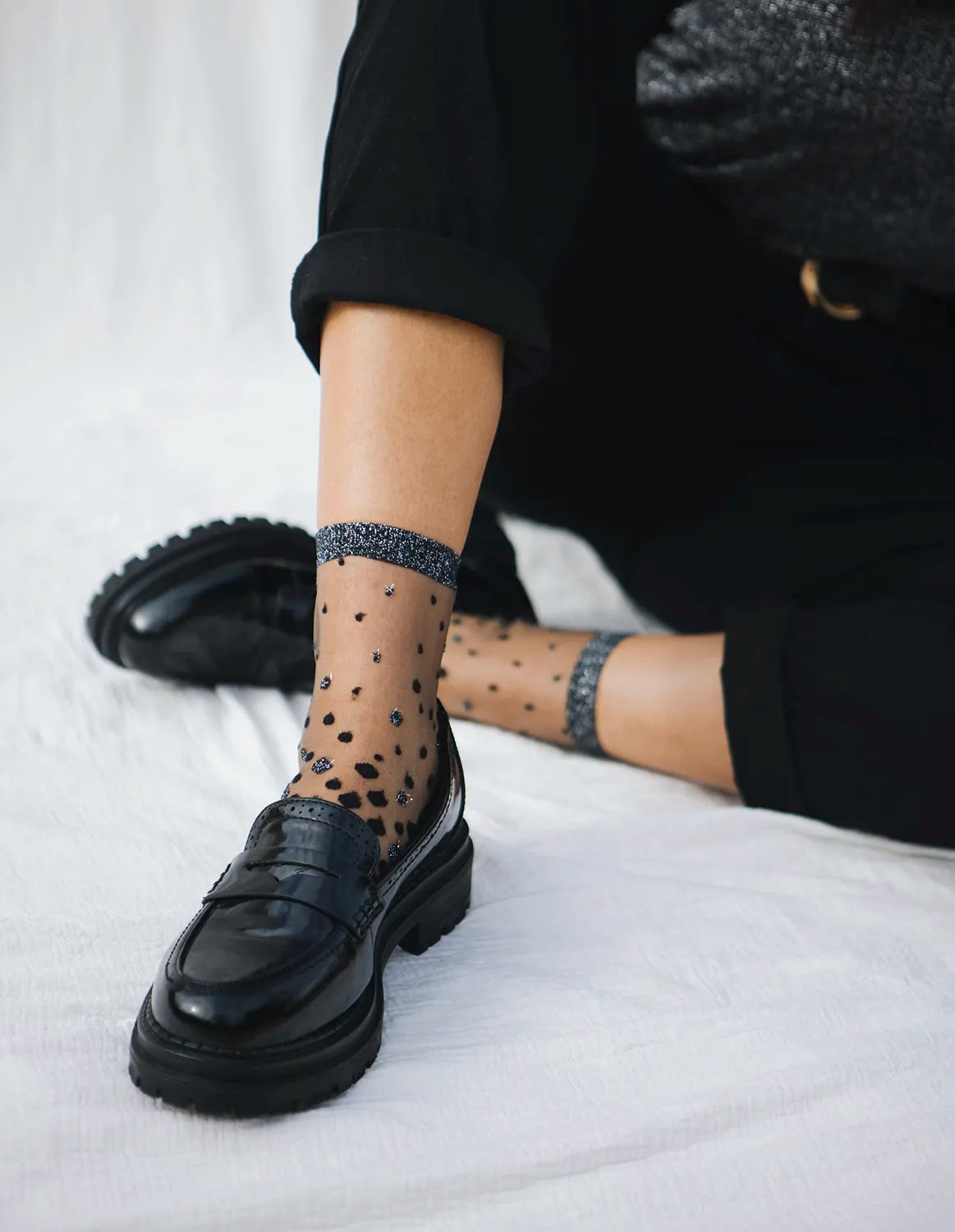 Paire de chaussettes transparentes à paillettes argentées Nakameguro silver Atelier St Eustache portées par une mannequin avec des moccassins noirs et une tenue de fête